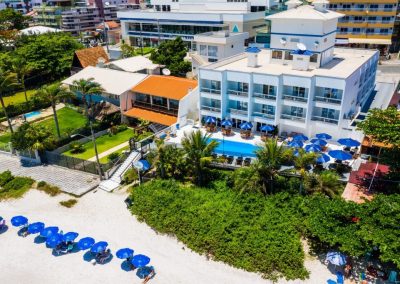 Bombinhas blue Suítes, um hotel na beira-mar de bombinhas, com vista aérea, mostrando piscina e sacadas dos apartamentos